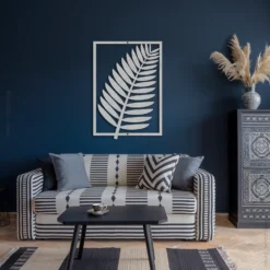 Silver colored tropical fern metal wall art above couch