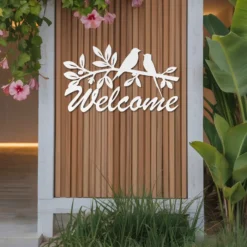White metal welcome bird sign outside display