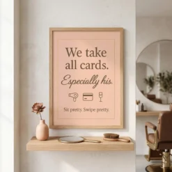 Close-up of blush pink funny salon payment poster showing the printed text, cute icons, and wooden frame texture