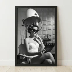 Black and white framed poster of a woman in rollers under a vintage hood dryer in a retro salon